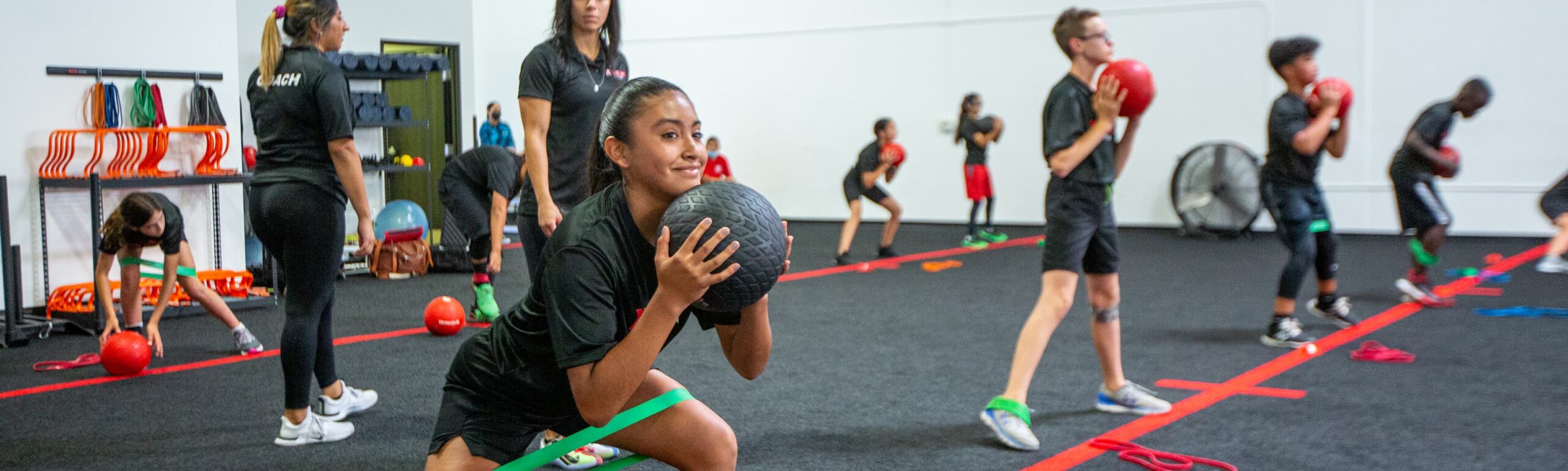 People squatting with exercise balls